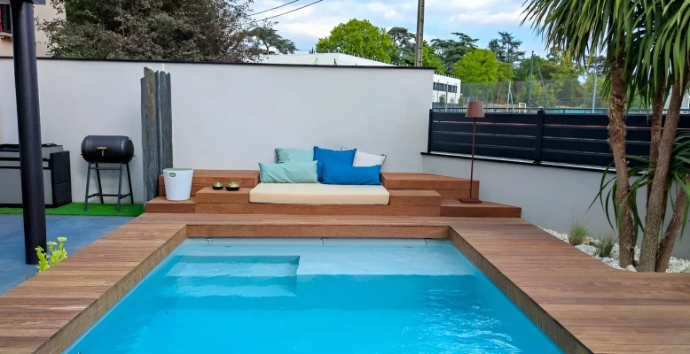 Piscine contemporaine avec terrasse en bois, intégrant élégamment nature et confort moderne.